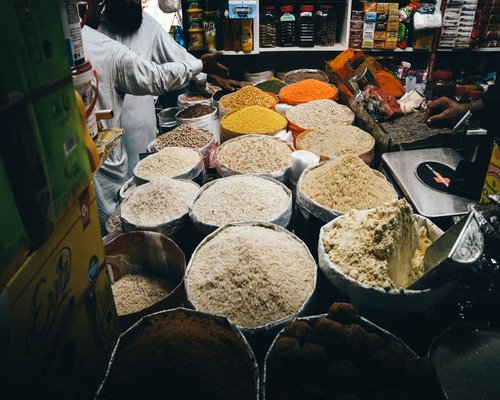 A well-organized Pakistani kitchen counter with everyday ingredients like lentils, vegetables, and flour